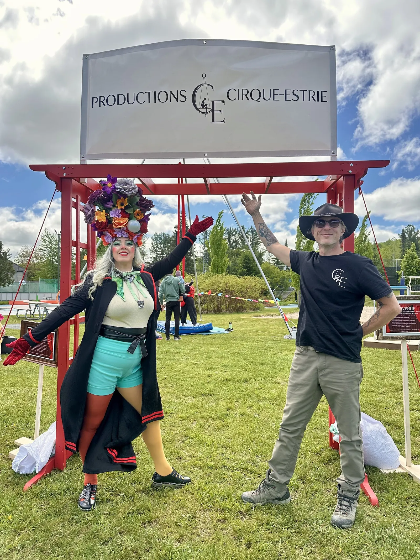 Deux artistes costumés devant le portique Productions Cirque Estrie