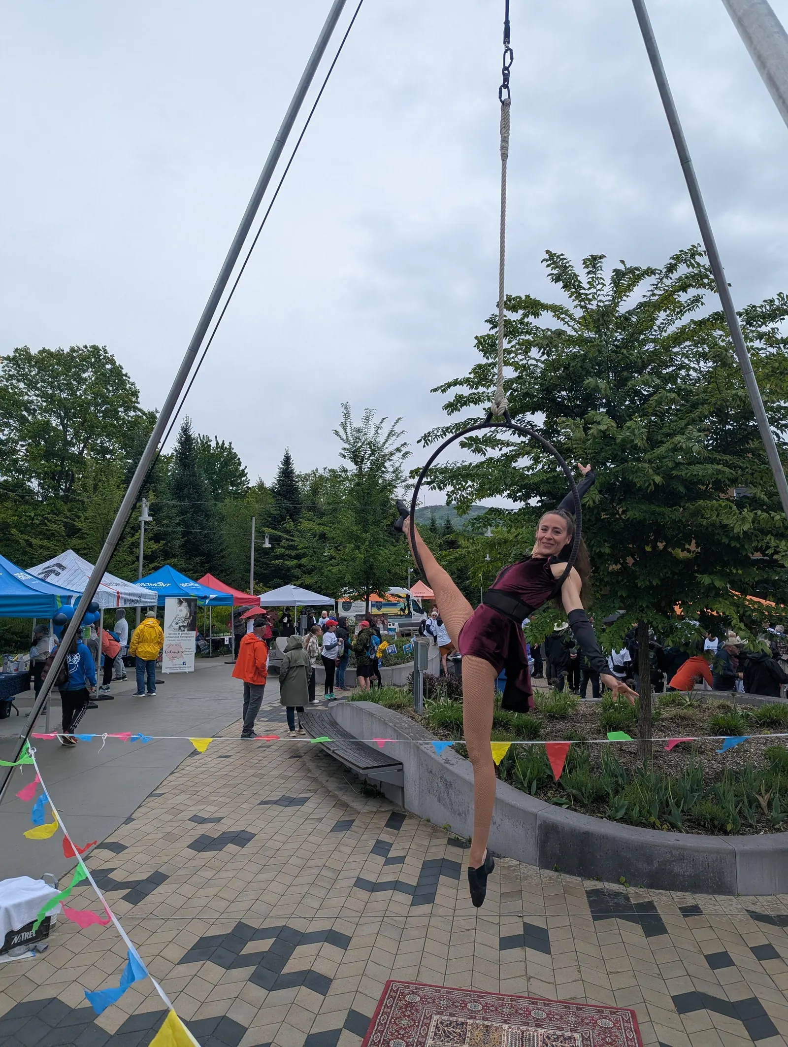 Artiste aérienne sur un portique au milieu du public d'un festival