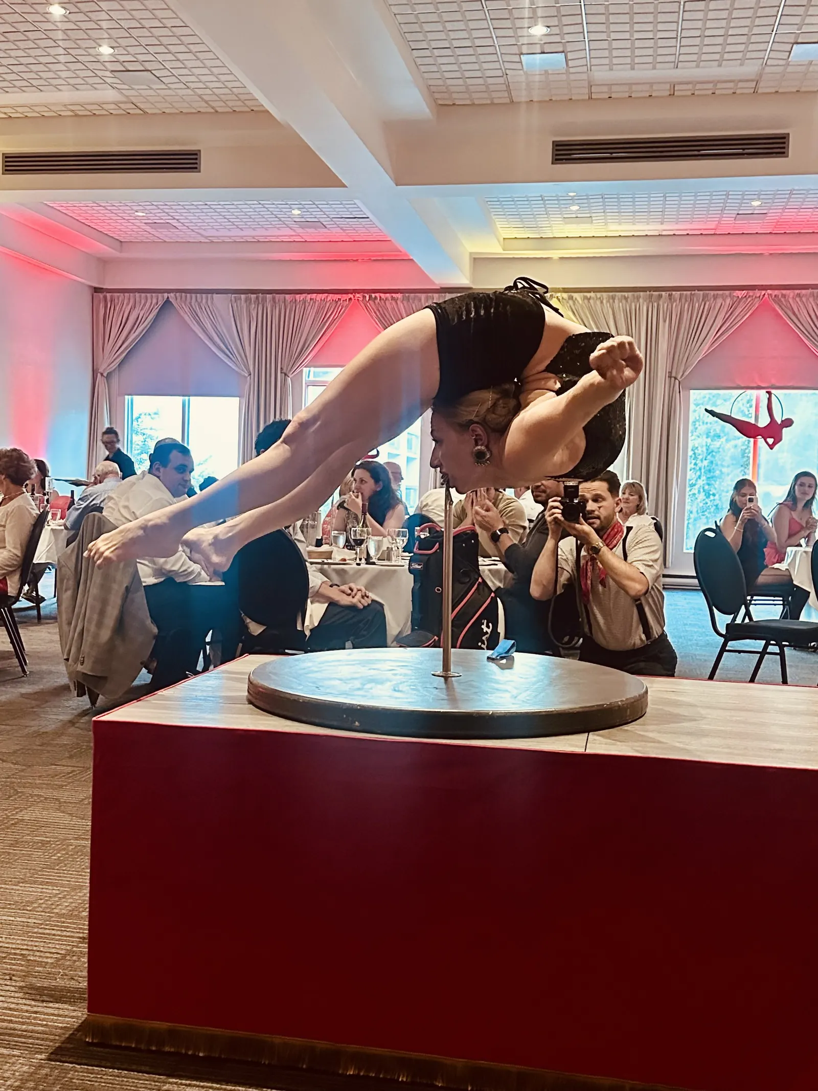 Contorsionniste en équilibre sur un podium au milieu des invités d'une réception